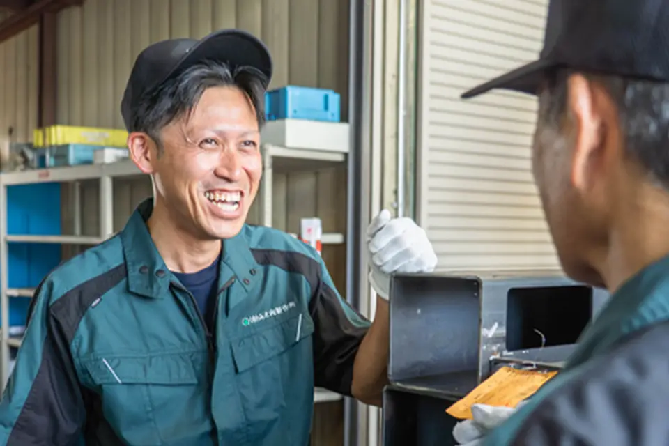 現場で笑顔で会話する社員